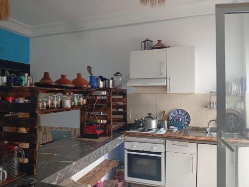 a kitchen with white cabinets and a stove top oven at Nouvelle ville Ibn Battouta in Tangier