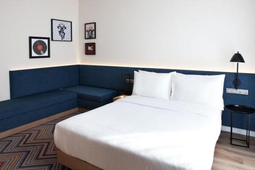 a hotel room with a bed and a couch at Hampton By Hilton Stuttgart Airport in Filderstadt
