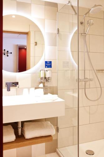 a bathroom with a sink and a shower at Hampton By Hilton Stuttgart Airport in Filderstadt