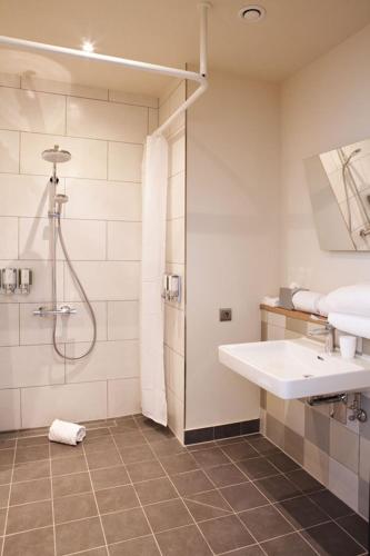 a bathroom with a sink and a shower at Hampton By Hilton Stuttgart Airport in Filderstadt