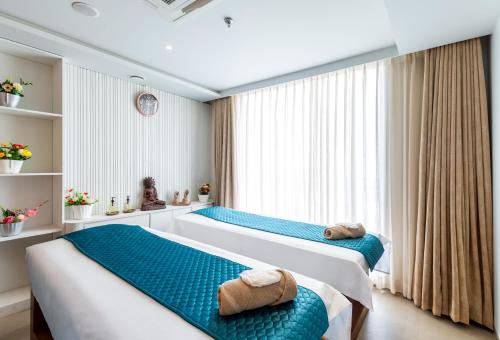 a bedroom with two beds and a large window at The Paradise Bliss - A Luxury Hotel & Spa in Udaipur in Udaipur