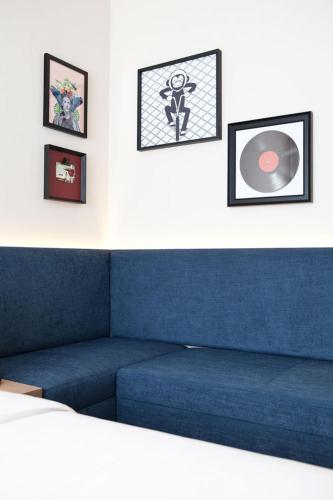 a blue couch in a room with pictures on the wall at Hampton By Hilton Stuttgart Airport in Filderstadt