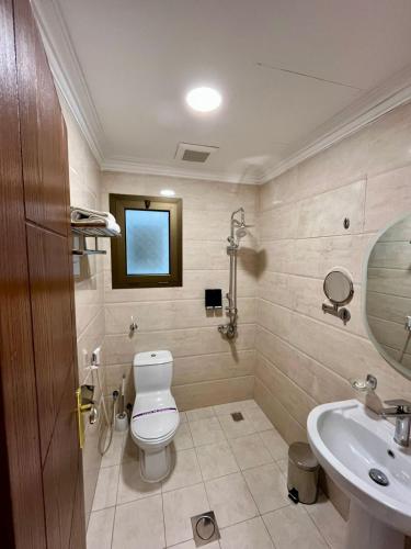 a bathroom with a toilet and a sink at لافانتا للشقق المخدومه - LAVANTA Hotel in Al Khobar