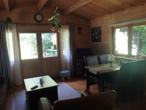 a living room with a table and chairs and windows at Huis H8 in Epe