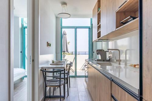 una cucina con un bancone con sedie e un tavolo di Santorini Wave Loft 2 a Gjilek