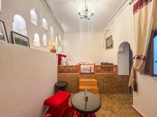 a room with a table and a red chair at Riad Al-Qurtubi in Tangier