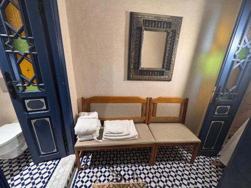 a bathroom with a bench with towels on it at Riad Al-Qurtubi in Tangier