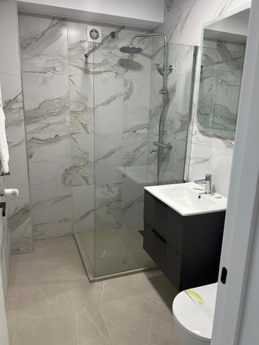 a bathroom with a shower and a toilet and a sink at Techirghiol Boutique in Techirghiol