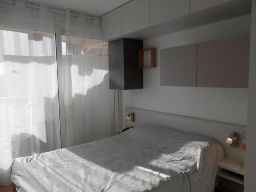 une chambre avec un lit et une porte coulissante en verre dans l'établissement T2 avec piscine, terrasse et parking à Vieux-Boucau - FR-1-379-81, à Vieux-Boucau-les-Bains