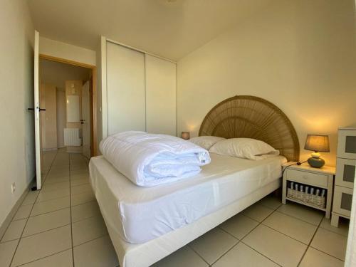 - une chambre dotée d'un lit avec des draps blancs dans l'établissement Appartement T2 avec terrasse, parking, animaux admis - FR-1-379-172, à Vieux-Boucau-les-Bains