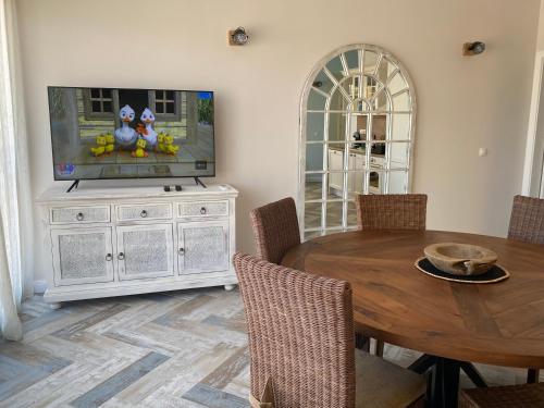 Un comedor con una mesa y un televisor de pantalla plana. en Coastal home Arapya, en Tsarevo