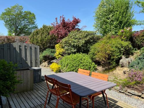 a wooden table and chairs on a wooden deck at Le Clos Sigebert in Libramont