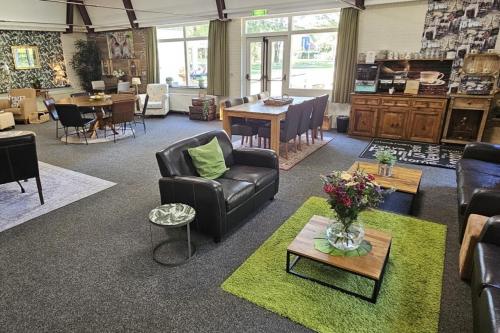 a living room with a couch and chairs and a table at Timmerholt Vakantiehuis 177 in Westerbork