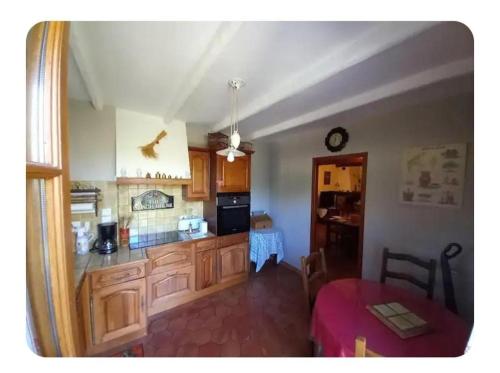 - une cuisine avec des placards en bois et une table dans une pièce dans l'établissement L'oliveraie, à Correns