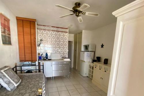 Il comprend une cuisine avec un ventilateur de plafond et un comptoir. dans l'établissement Apartment of 26 m2 with view on the boats, à Gruissan