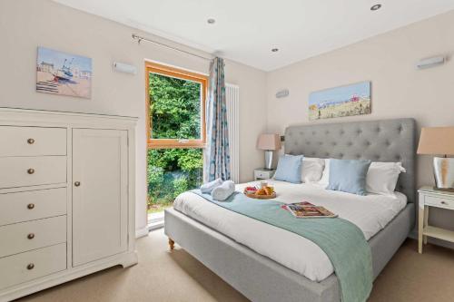 a bedroom with a large bed and a window at House 4 in Looe