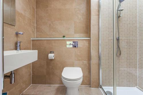 a bathroom with a toilet and a sink and a shower at House 4 in Looe