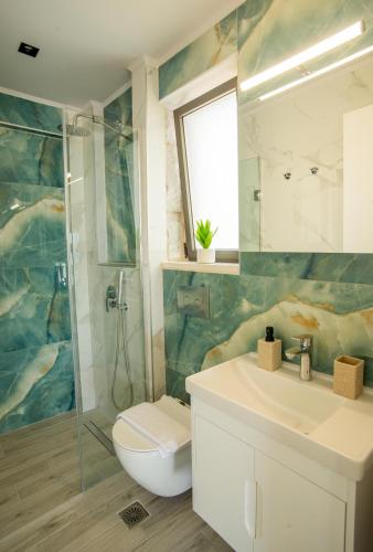 a bathroom with a toilet and a sink and a shower at Sunrise Villas Collection in Polychrono