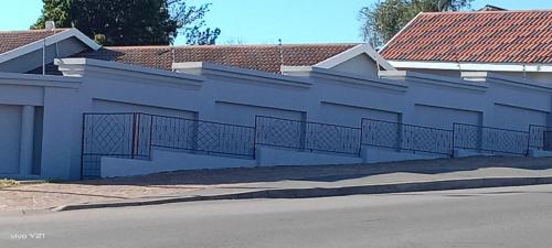 a blue building with a fence on the side of a street at Zuzani Ikhaya B&B in Grahamstown