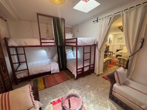 a bedroom with two bunk beds and a couch at Riad Al-Qurtubi in Tangier