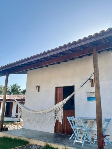 a house with a hammock outside of it at Zema Bangalôs in Trairi