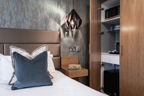 a bedroom with a bed with a blue pillow at The Jade in London