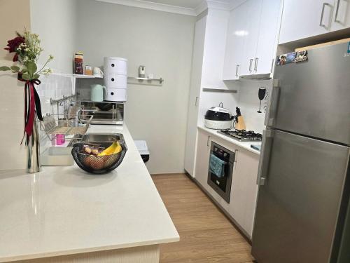 a kitchen with a bowl of fruit on a counter at Stylish 2-Bedroom Apartment in Maddington, 15 Minutes from Perth Airport in Perth
