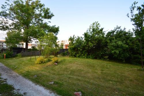 a grassy hill with trees and a building in the background at Lovely&Cozy authentic atmosphere in Tallinn