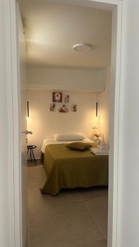 a bedroom with a bed with a green blanket at Nina Mia in Fasano