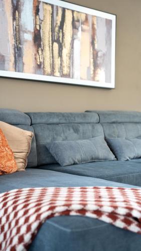 a blue couch in a living room with a painting at Rise House in Livingston
