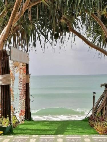 an entrance to a beach with palm trees and a sign at Beach Home Lanta in Ko Lanta