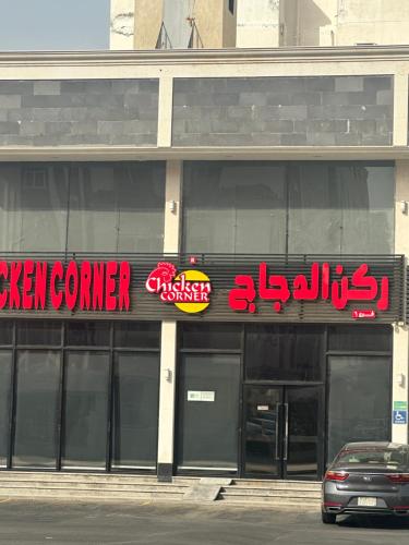 a building with neon signs on the side of it at بيت عز اقامة راقية in Aţ Ţunḑubāwī
