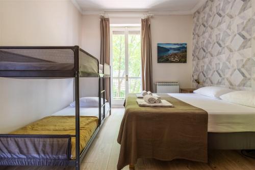 a bedroom with two bunk beds and a window at IseoLakeRental - Casa Massimo in Lovere