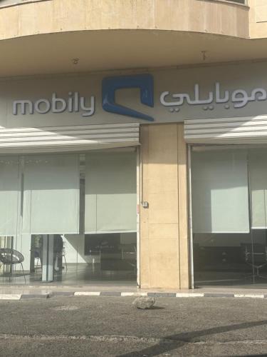 a store front of a mall with aania sign on it at بيت عز اقامة راقية in Aţ Ţunḑubāwī