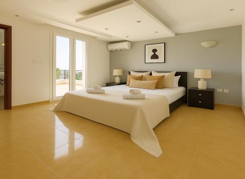 a large bedroom with a large white bed with pillows at Appartement Charmant à Hydra in Hydra