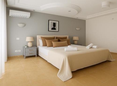 a bedroom with a large white bed and two lamps at Appartement Charmant à Hydra in Hydra