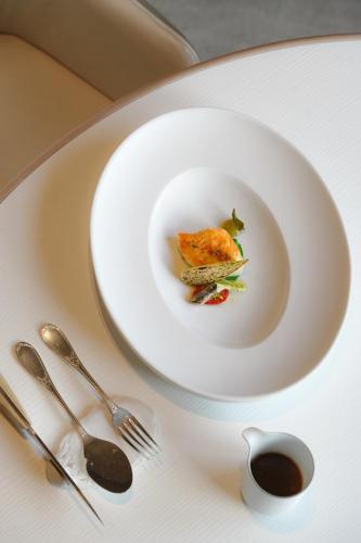 a white plate with a piece of food on a table at L'Hôtel & Spa du Castellet in Le Castellet