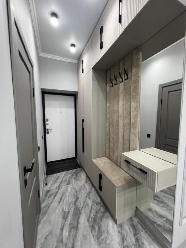 - un dressing avec un banc et une porte dans l'établissement ЖК САТПАЕВа, à Pavlodar