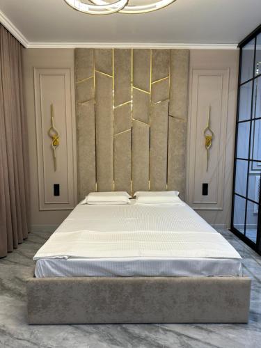 une chambre avec un grand lit dans une pièce dans l'établissement ЖК САТПАЕВа, à Pavlodar