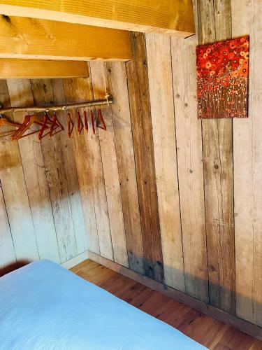 a room with a wooden wall with a bed at La noisette in Florennes