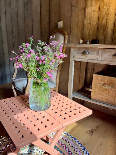 a vase of pink flowers sitting on a table at La noisette in Florennes