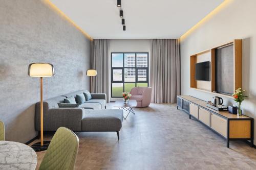 a living room with a couch and a tv at JA The Manor Hotel, Dubai in Dubai