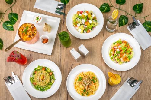 a table with white plates of food on it at JA The Manor Hotel, Dubai in Dubai