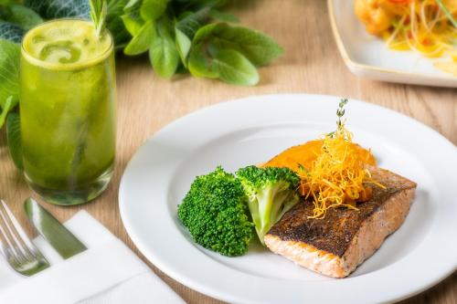a plate of food with broccoli on a table at JA The Manor Hotel, Dubai in Dubai