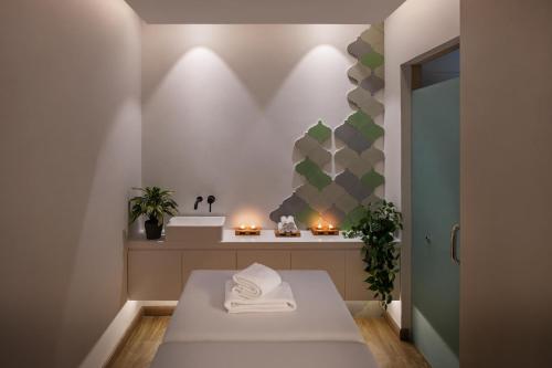 a bathroom with a table with towels on it at JA The Manor Hotel, Dubai in Dubai