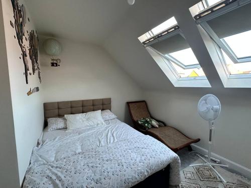 a bedroom with a bed and two skylights at Cosy Double Room in a Private Home in Buckingham, just a 10-minute stroll to the town! in Buckingham