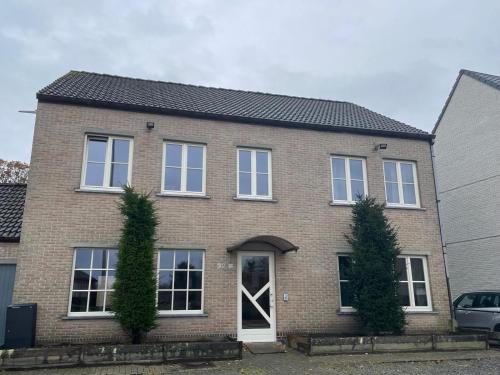 a brick house with a white door at Rent and Relax Geel in Geel
