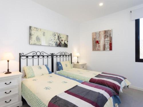 two beds in a bedroom with white walls at Live El Poris Rodelas in Arico
