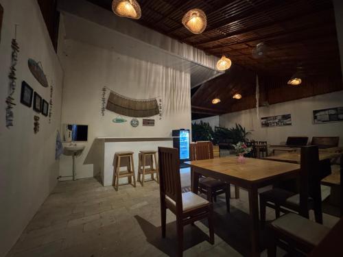 a dining room with a wooden table and chairs at mc villa bunaken in Bunaken