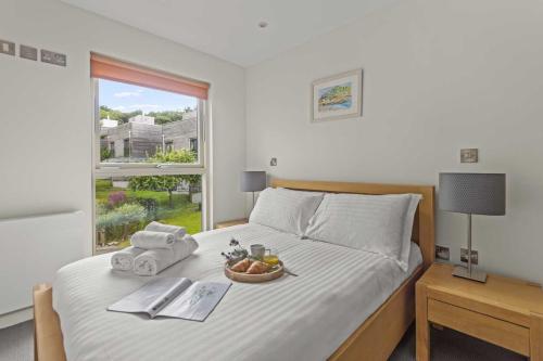 a bedroom with a bed with a bowl of fruit on it at House 8 in Looe